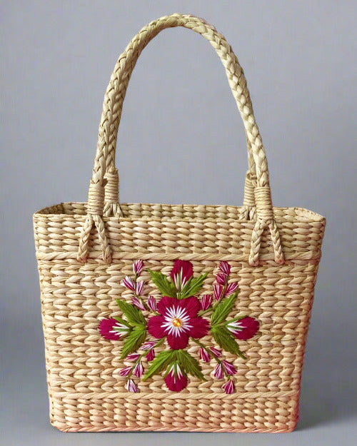 Woven basket with floral embroidery on a pink and white floral background