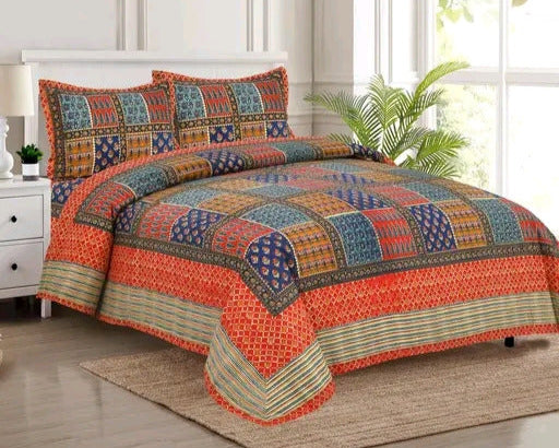 Colorful patchwork bedspread set on a bed in a bright room with a plant.