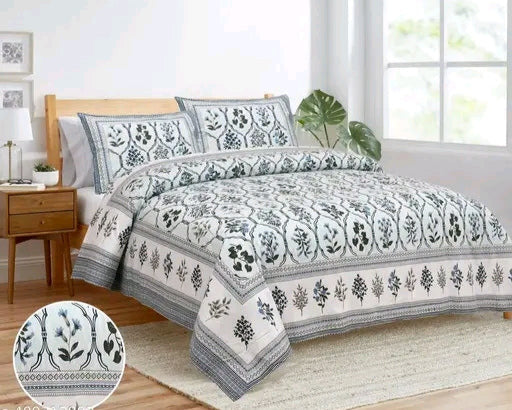 Bedding set with floral pattern on a bed in a well-lit room.