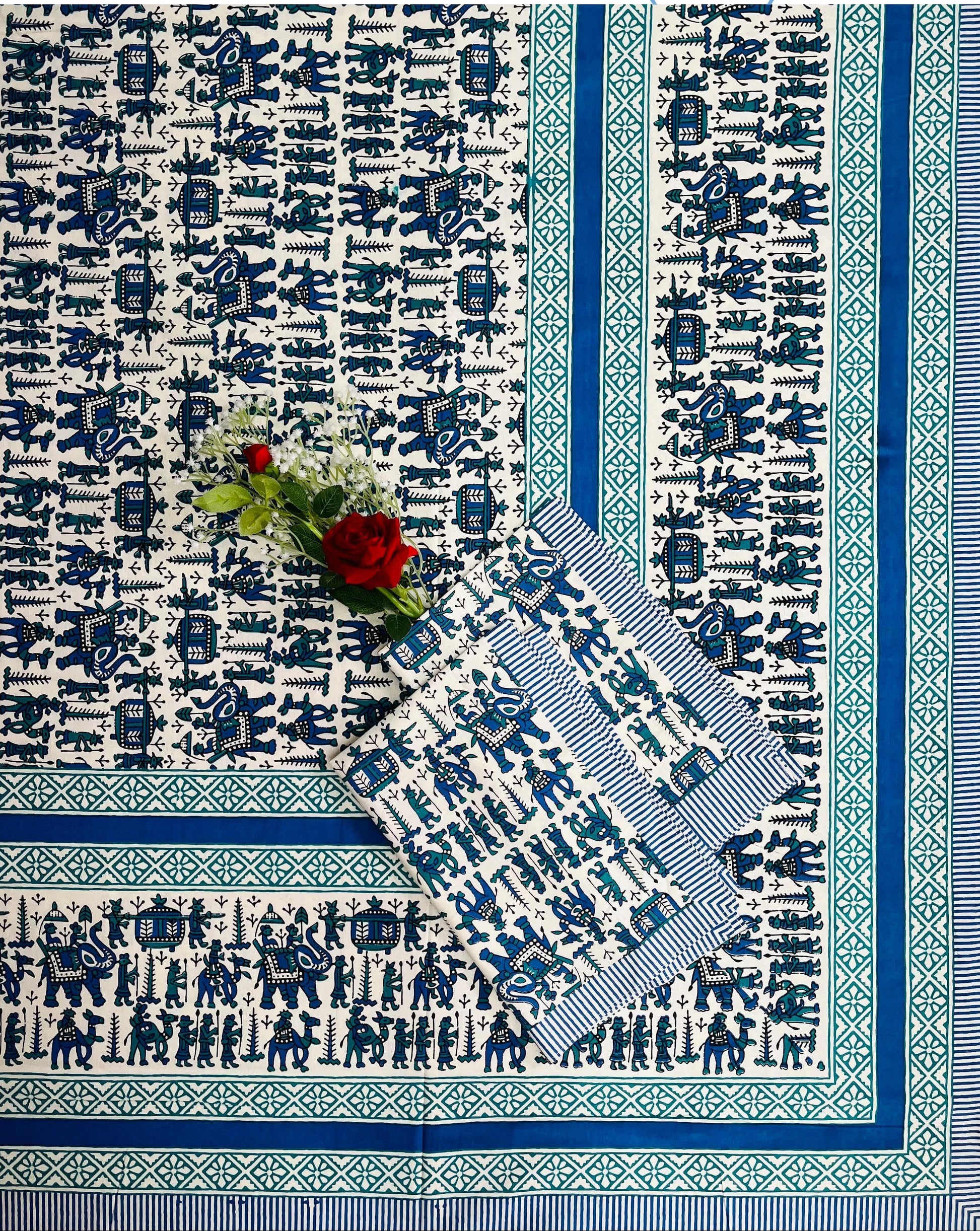 Blue and white patterned tablecloth with a floral arrangement on a white background