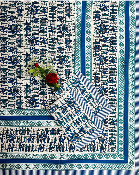 Blue and white patterned tablecloth with a floral arrangement on a white background