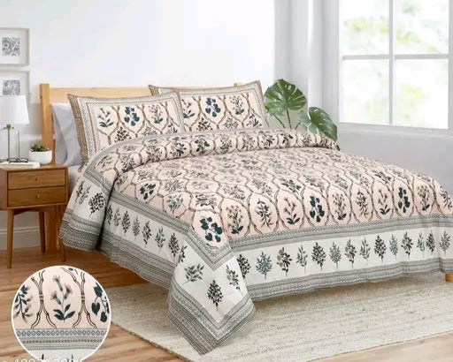 Floral patterned bedspread set on a bed in a bright bedroom.